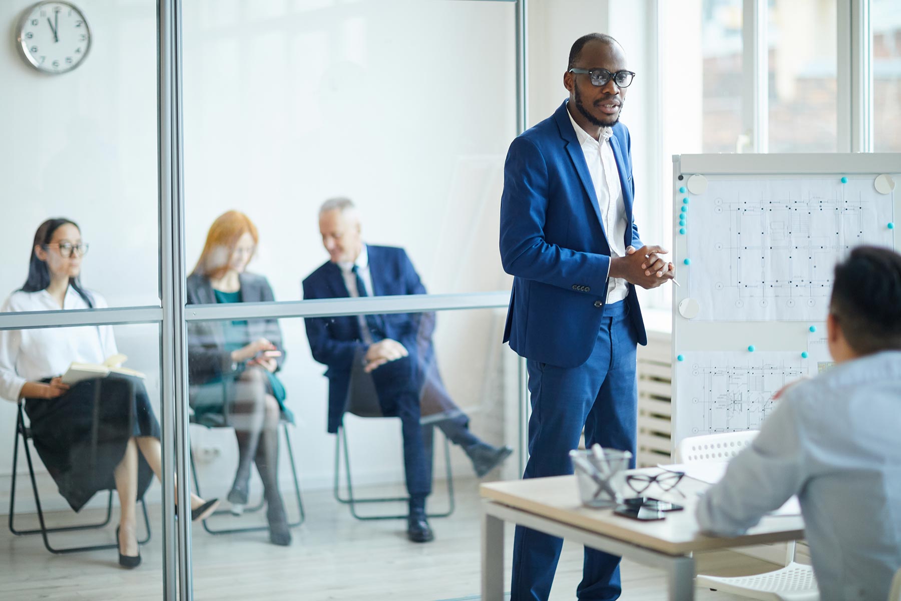 african-man-pitching-ideas-to-management-T44GTU2