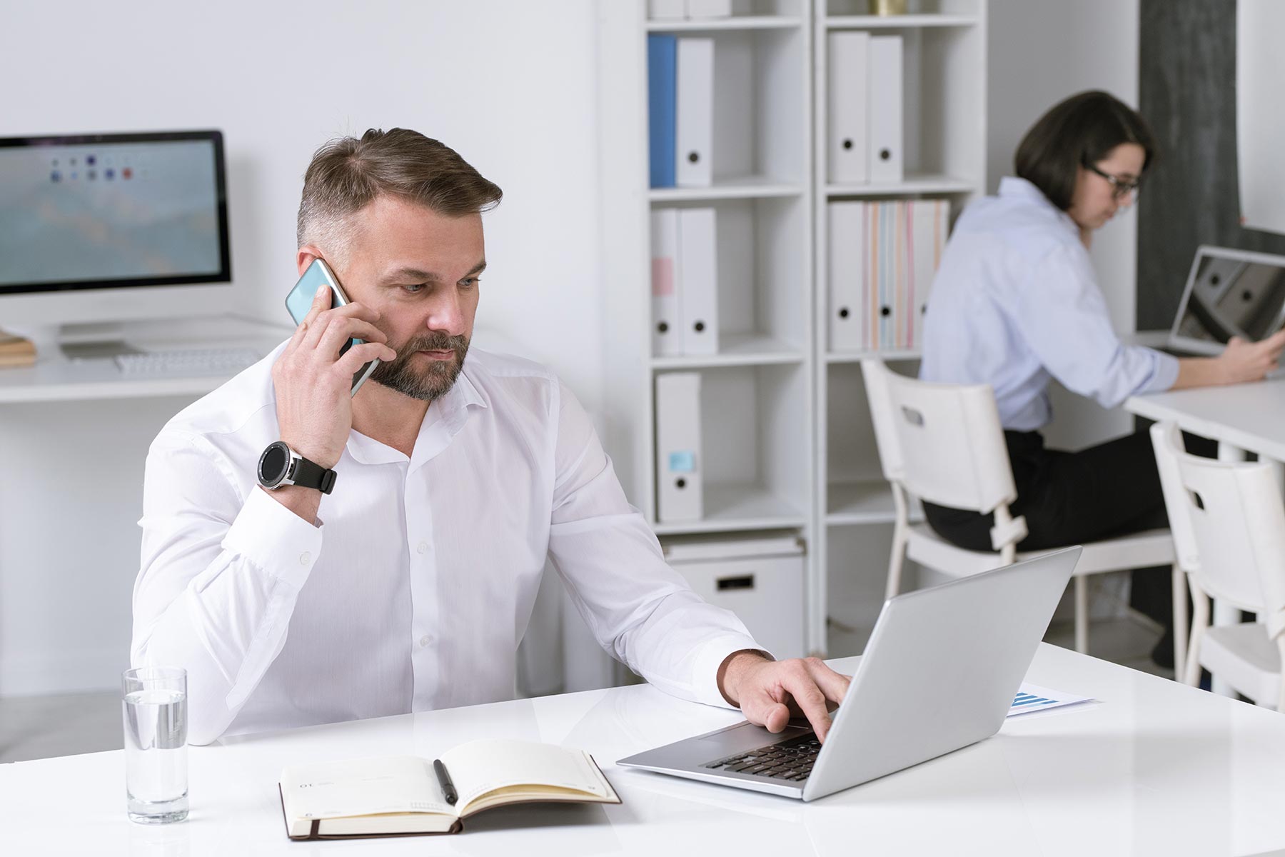 serious-mature-businessman-with-smartphone-talking-D8358AK